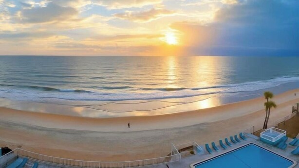 Vista de una playa con piscina y sillas de descanso.