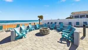 Una terraza en la azotea con mobiliario exterior, un hogar para fuego y vistas al océano.