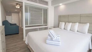 Un dormitorio con cama, una silla y una ventana con persianas.