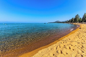 A beach with clear water, a sandy shore, and a forested area in the background. - Cozy 1-bedroom condo with AC in fabulous South Lake Tahoe (South Lake Tahoe)