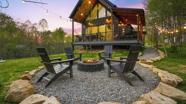 A cabin with a deck, outdoor seating, and a fire pit. - Spiral Loft · Hot Tub · Spa Bath | Lux Sleeps 4 (McArthur)