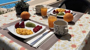 Ett matbord med frukostmat och utsikt över en swimmingpool.