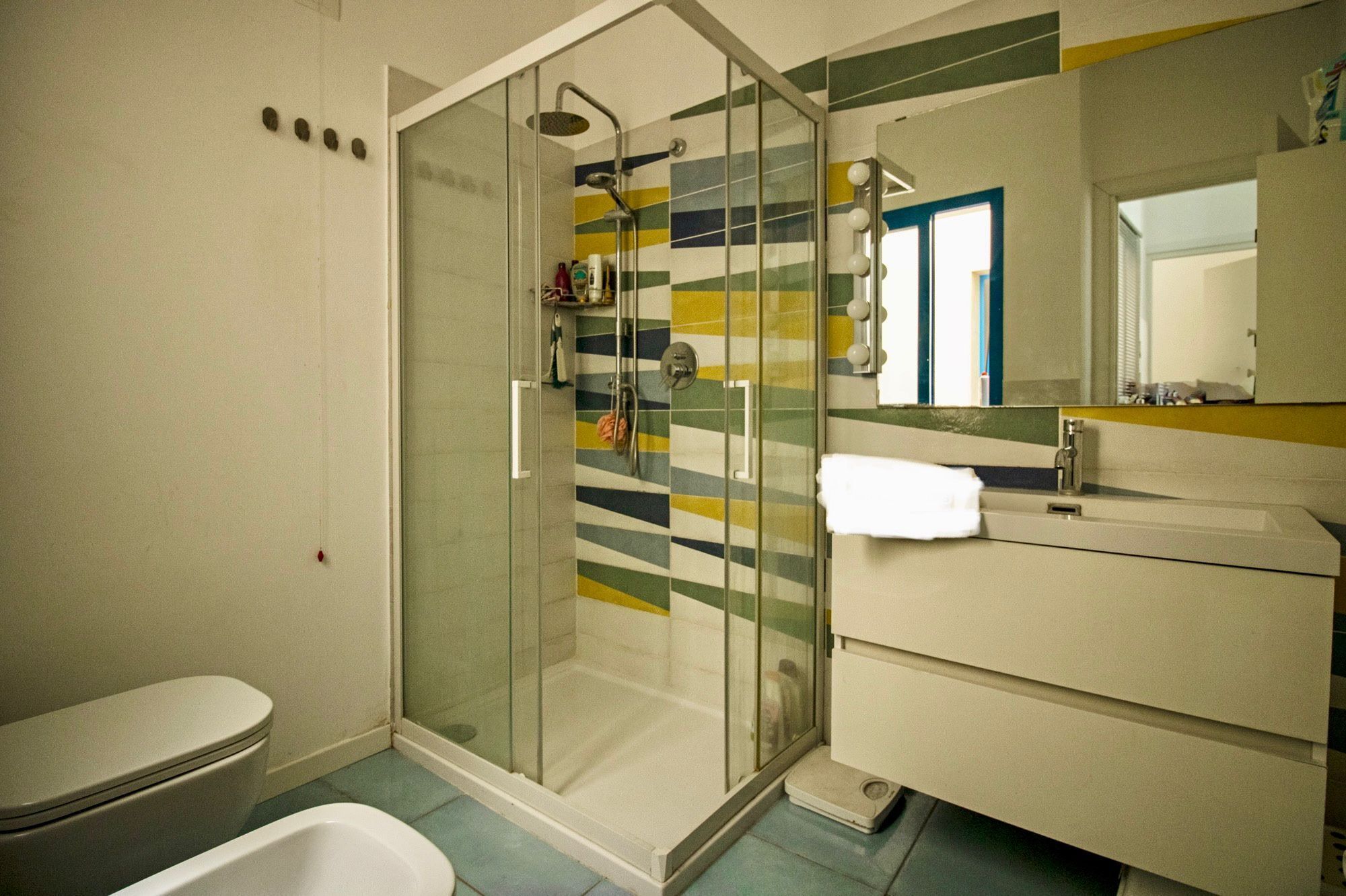 A bathroom with a shower, toilet, and sink.