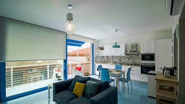 A modern apartment with a dining area, kitchen, and a balcony with a view. - Blue House Relax -Cozy family apartment 3 minutes from the sea (Marina di Ragusa)