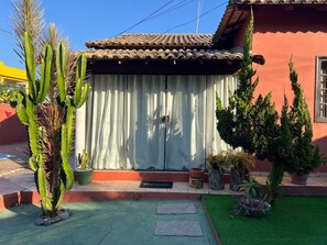 A house with a tiled roof, a cactus, and various potted plants. - RETREAT IN MARICÁ: SUNSET POOL AND DECK. (Maricá)