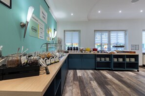 A buffet area with various food options and a counter with utensils. - Hotel Am Seegraben Cottbus (Cottbus)
