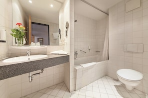 A modern bathroom with a sink, mirror, and shower.