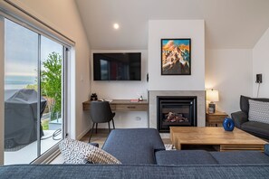 Ein modernes Wohnzimmer mit Kamin, Flachbildfernseher und einer Couch.