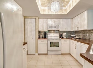A kitchen with white cabinets, a microwave, an oven, and a dishwasher. - Divine Condo, Cozy 2-bedroom 1st floor condo with AC in quaint Estero! (Estero)