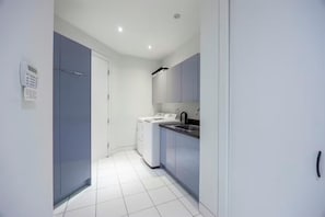 A modern kitchen with a washing machine, a sink, and cabinets. - Wonderful 6-bedroom house in Richmond perfect for family getaways (Richmond)