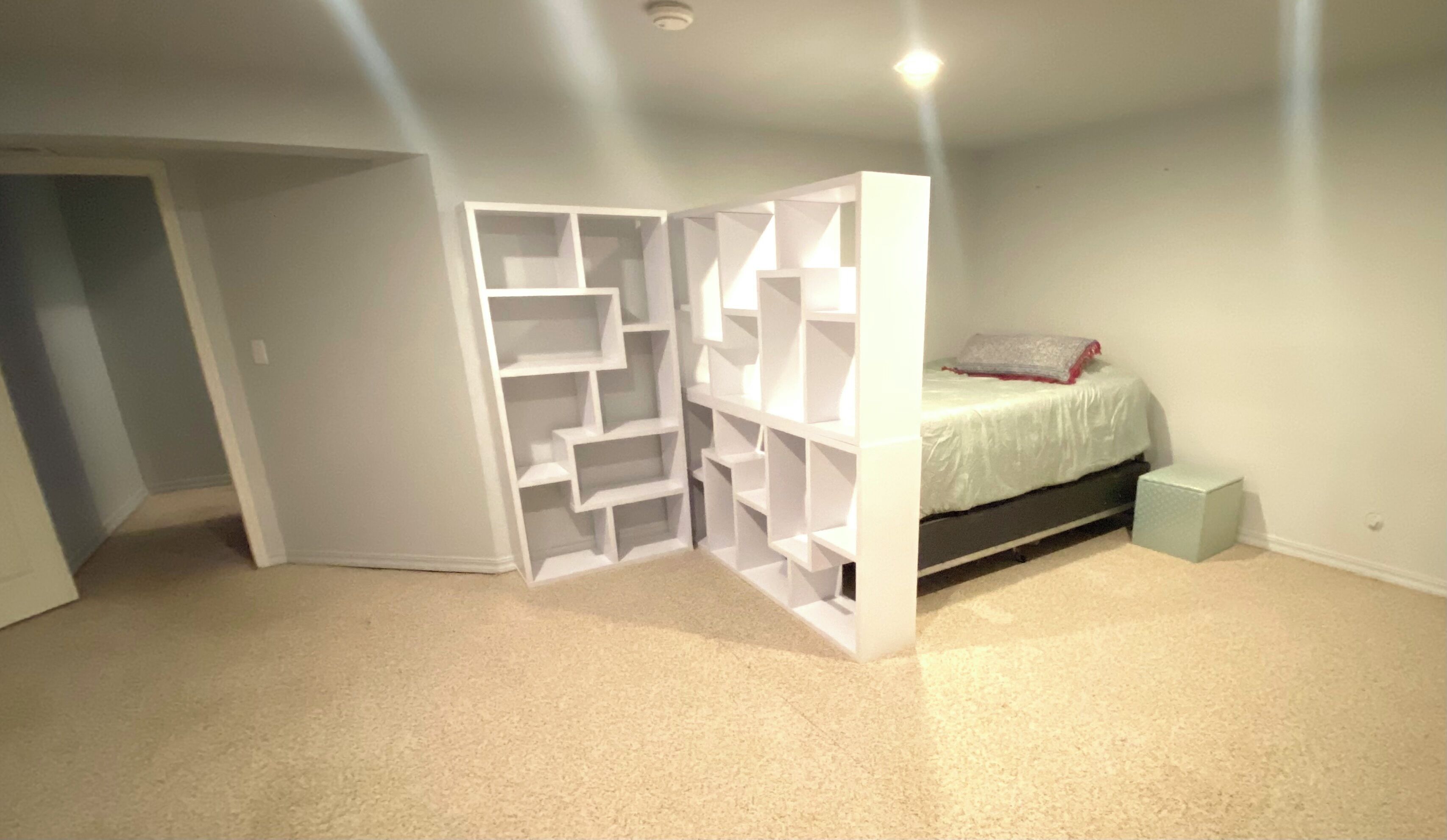 Um quarto com roupeiro embutido, uma cama e uma pequena mesa de cabeceira.