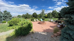A patio area with outdoor seating, a fire pit, and a view of a grassy field and trees. - 3-bedroom townhome in enchanting Parker - minimum 6m lease (Parker)