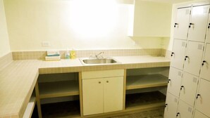 A small kitchenette with a sink, a countertop, and a cabinet. - The Barre (Koror)