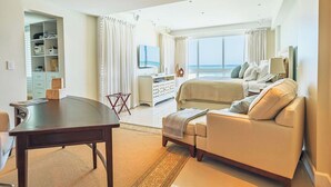 Ein Hotelzimmer mit Bett, Sofa, Schreibtisch und Meerblick.