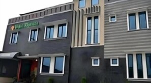 A modern building with multiple windows, a visible entrance, and a sign that reads 'Hotel'. - Hotel Khalista (Purwakarta)