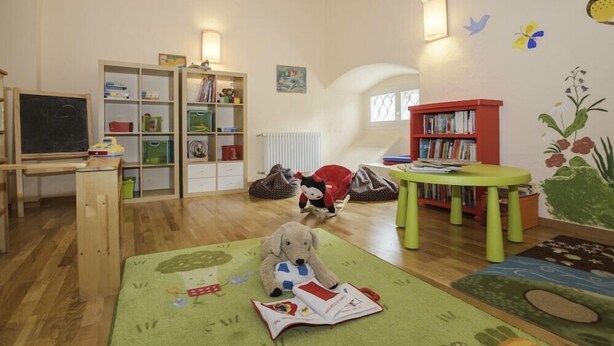 A room with a wooden desk, a bookshelf, a red chair, and a stuffed toy. - Jufa Meersburg am Bodensee (Meersburg)