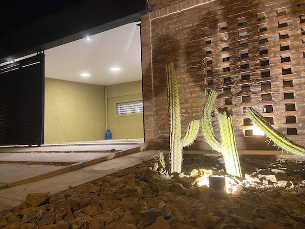A cactus garden with a brick wall and a water feature.