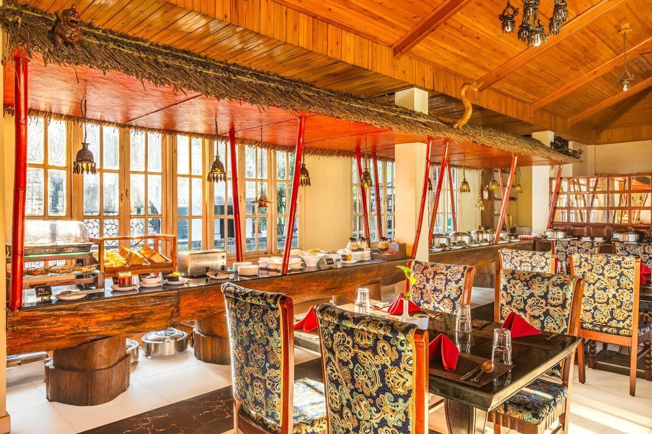 A restaurant with wooden interior, large windows, and a buffet area.