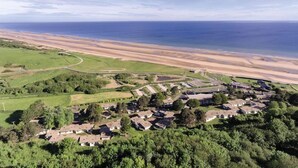 Une zone résidentielle côtière avec des maisons, une plage et un ciel dégagé.