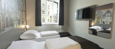 Une chambre d’hôtel avec deux lits, une grande fenêtre, un téléviseur à écran plat et une fresque représentant un bâtiment.