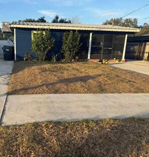 Une propriété résidentielle dotée d’un garage, d’un porche abrité et d’une pelouse.