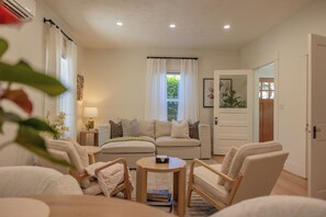 A living room with a sofa, armchairs, a small table, and a window with curtains. - Chico Charmer ~Near Chico State University & Downtown Chico-Pet Friendly (Chico)