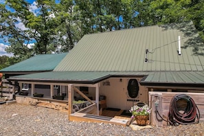 A building with a green metal roof, a wooden porch, and a welcome sign. - Lakefront Retreat on High Rock Lake - Dock, Kayaks & Game Room (Denton)