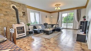 Ein Wohnzimmer mit Kamin, einer Sofagarnitur, einem Couchtisch und einem Fernseher.