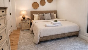 Un dormitorio con cama, mesita de noche, lámpara y decoración en la pared.