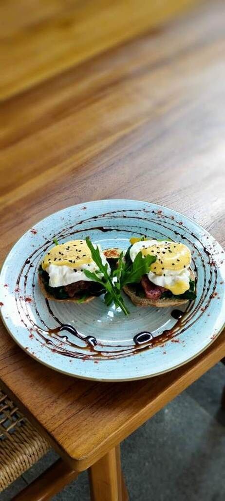 Un plato con un sándwich y verduras sobre un plato de cerámica.