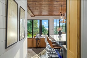 Ein modernes Interieur mit Essbereich, großen Fenstern und Blick ins Freie.