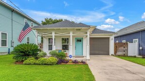 A residential house with a covered porch, a garage, and a well-maintained lawn. - 3-bedroom house with fenced yard and private pool (Pensacola)
