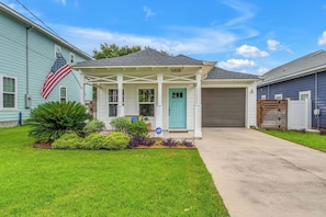 A residential house with a covered porch, a garage, and a well-maintained lawn. - 3-bedroom house with fenced yard and private pool (Pensacola)