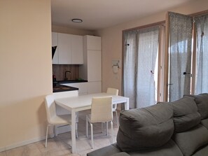 Ein kompakter Wohnbereich mit Küchenzeile, Esstisch und Sofa.
