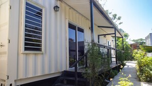 A mobile home with a porch, a staircase, and a small garden area. - A unique stay steps from the beach with breakfast included (Rincón)