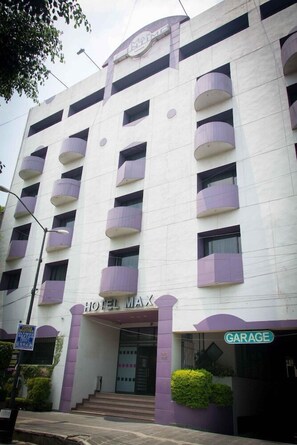 A multi-story building with a sign reading 'HOTEL MAX' and a 'GARAGE' sign below. - Maxintimo Hotel (Mexico City)