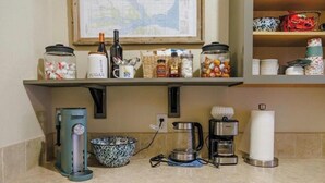 A kitchen counter with a coffee maker, kettle, and sugar jar. - McCall Basecamp (Donnelly)