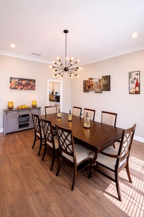A dining room with a wooden table, six chairs, a chandelier, and artwork on the walls. - 1-Story Ranch -- Fishing --Two Kings -- 85" TV -- 4Bedroom (Mount Pleasant)