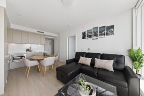 A modern apartment with a kitchen, dining area, and living room.