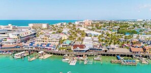 A coastal town with a marina, waterfront buildings, and a pier.