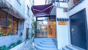 A narrow alleyway leading to a building with a glass door entrance, a staircase, and a metal door. - Gongxili - Chujian Hotel (Kunming)