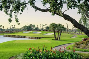 A golf course with sand bunkers, a water body, and a wooden dock. - Palm Aire Luxury Retreat - Golf, Beaches, Siesta Key & Sarasota Attractions (Sarasota)