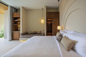 Ein modernes Schlafzimmer mit einem großen Bett, Einbauschränken, einer Sitzecke und einem Kleiderschrank.