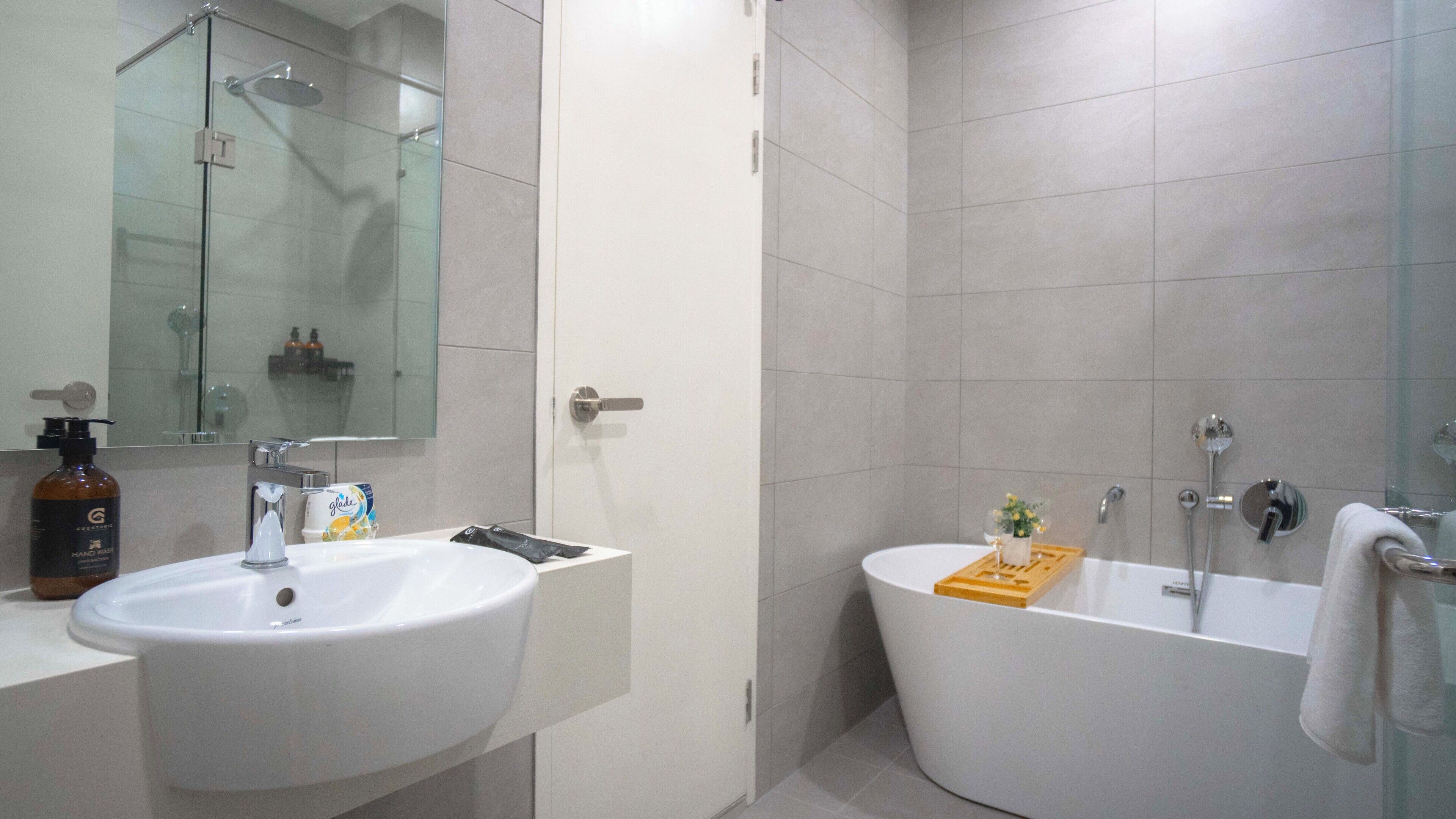 Un baño moderno con un lavamanos grande, un espejo, una ducha y una bañera.