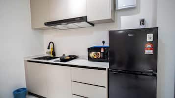 Apartamento Deluxe, 1 habitación | Cocina privada | Frigorífico, microondas, placa de cocina y mesa de comedor