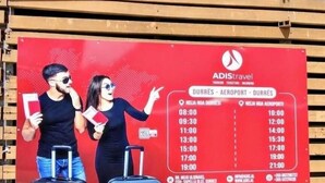 A red sign with a flight schedule for Durrës - Aeraport - Durrës. - Backpackers La Casa De Payaso (Durres)