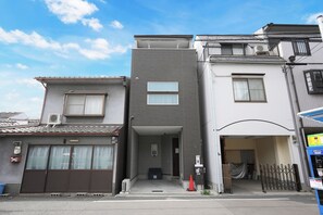 A residential building with a garage, a covered entrance, and a small porch area.