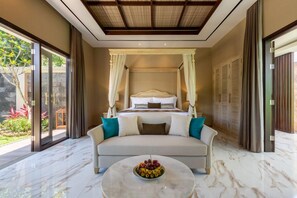 A bedroom with a large bed, a sofa, and a coffee table with fruit. - The Gantari Ubud Bali (Ubud)