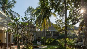 A well-maintained outdoor area with a paved walkway, seating arrangements, and lush greenery. - The Gantari Ubud Bali (Ubud)