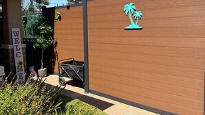 A wooden wall with a 'WELCOME' sign and a palm tree decoration.